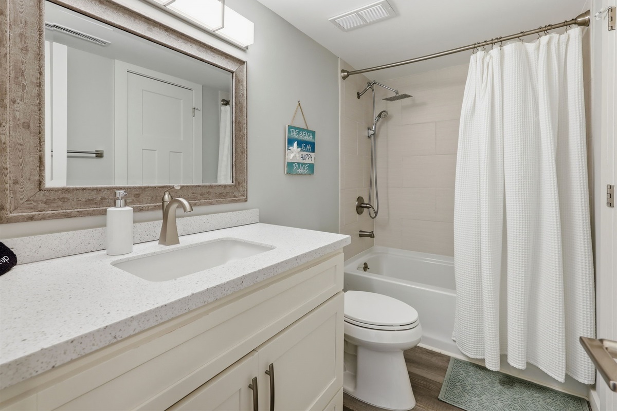 Hallway bathroom with a full tub and shower combo