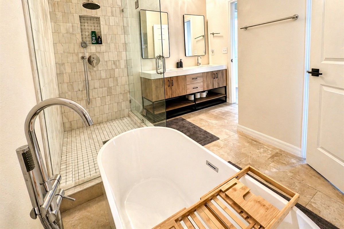 Relax and unwind in this spa-inspired bathroom featuring a deep soaking tub, elegant chandelier lighting, and calming modern décor designed for a luxurious retreat experience.