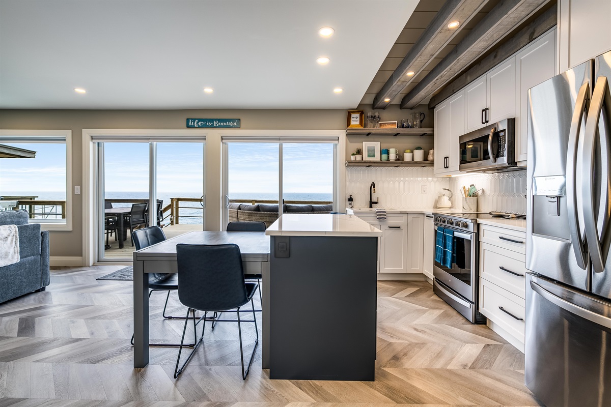 Fully equipped kitchen with stainless steel appliances including a dishwasher, microwave, fridge/freezer combo with water filter and ice maker, and an electric stove/oven combo.