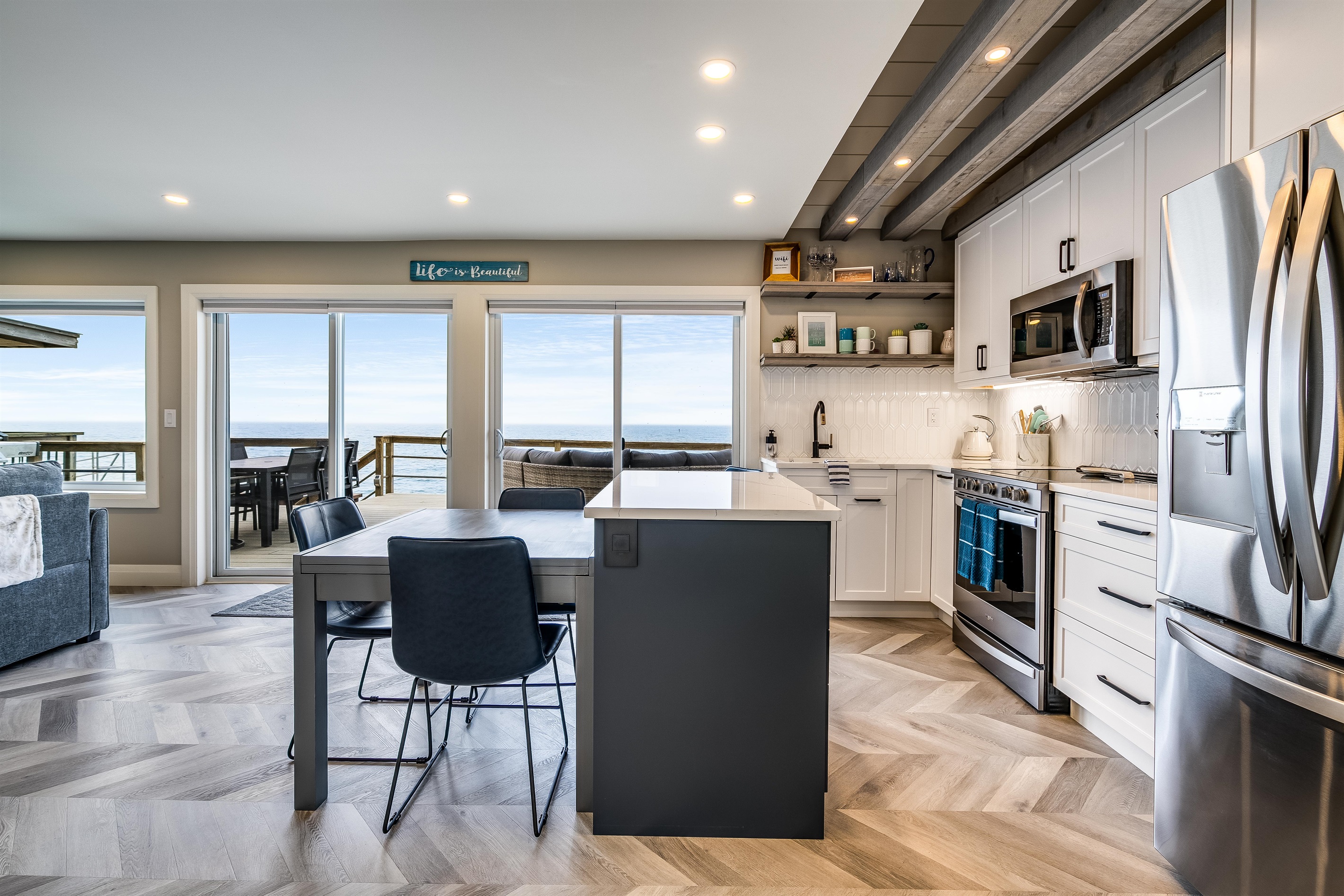 Fully equipped kitchen with stainless steel appliances including a dishwasher, microwave, fridge/freezer combo with water filter and ice maker, and an electric stove/oven combo.