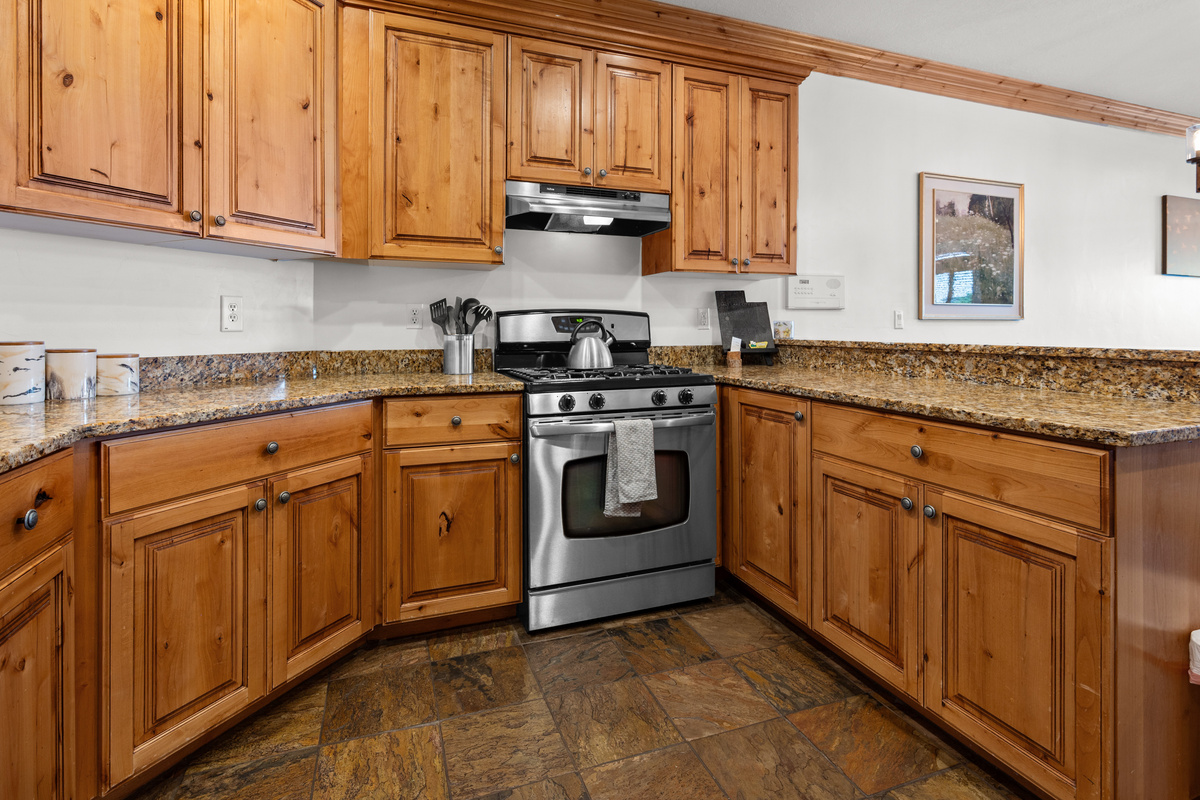 Warm wood cabinetry and generous counter space make preparing meals at home easy and enjoyable.