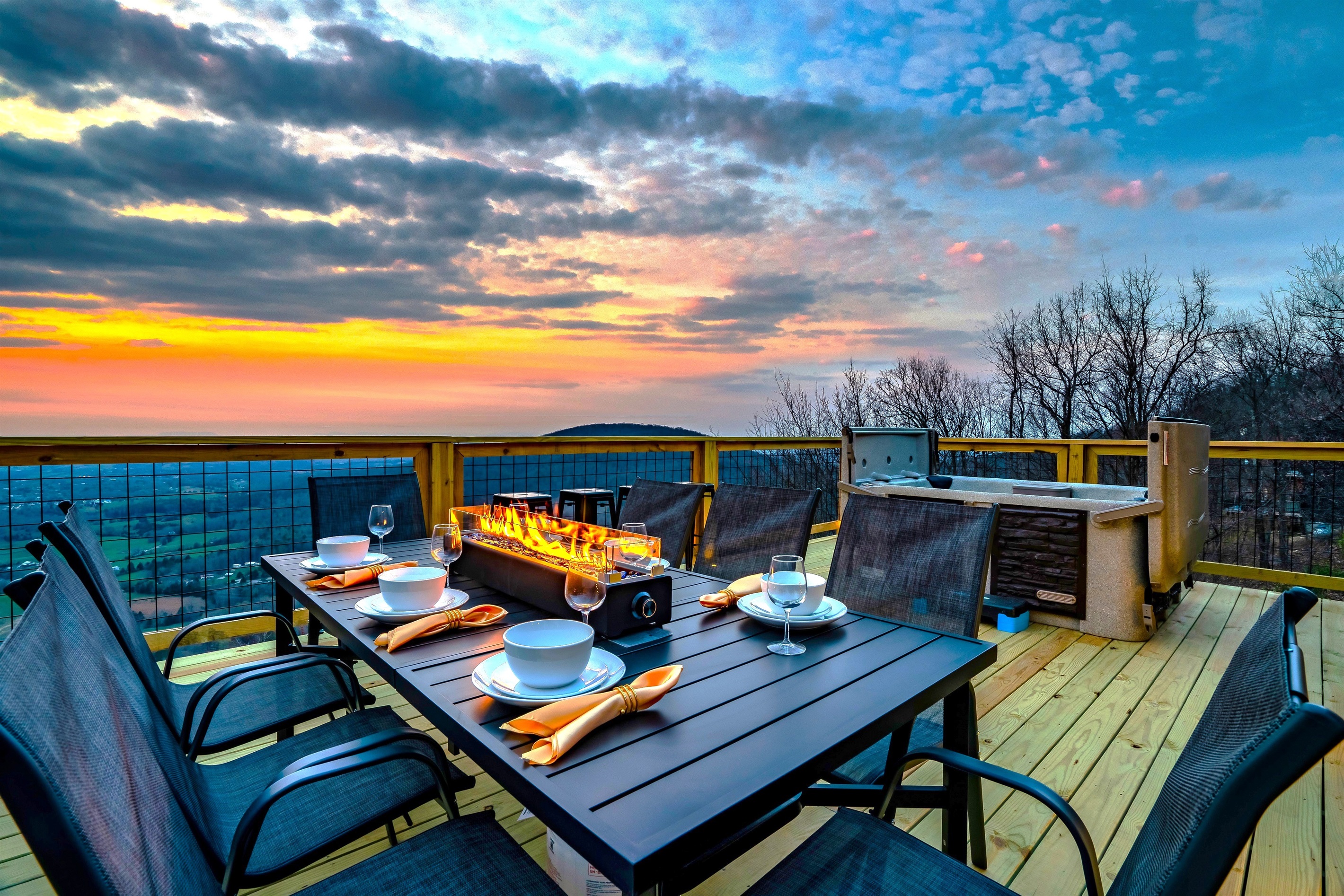 Outdoor dining at its best. Firepit table to set the mood, complete with a sweeping sky showing off its golden rays as your wallpaper!