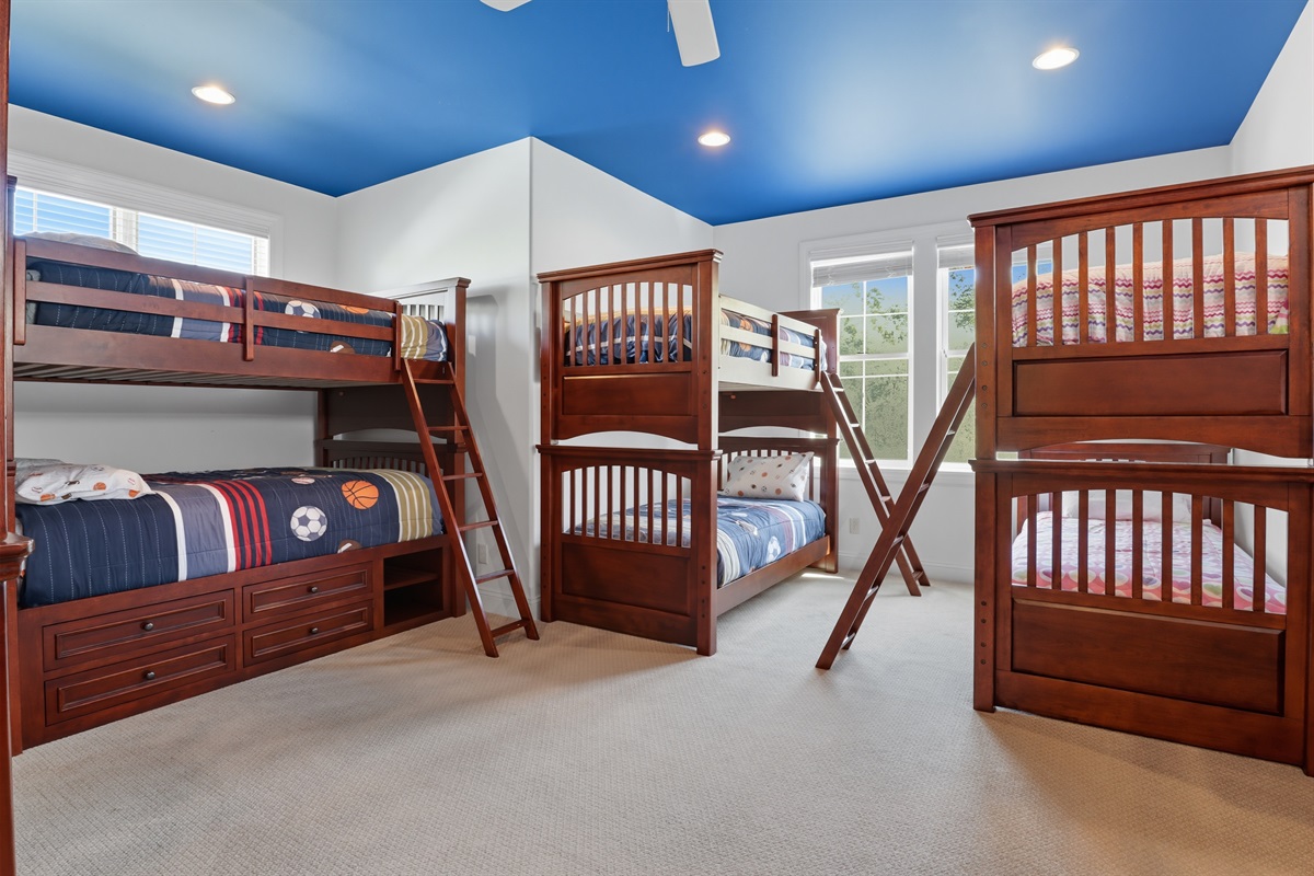 Spacious upstairs bunk room with 3 bunks featuring full mattresses on top and bottom and 2 bunks with twin mattresses on top and bottom. Bedroom #5