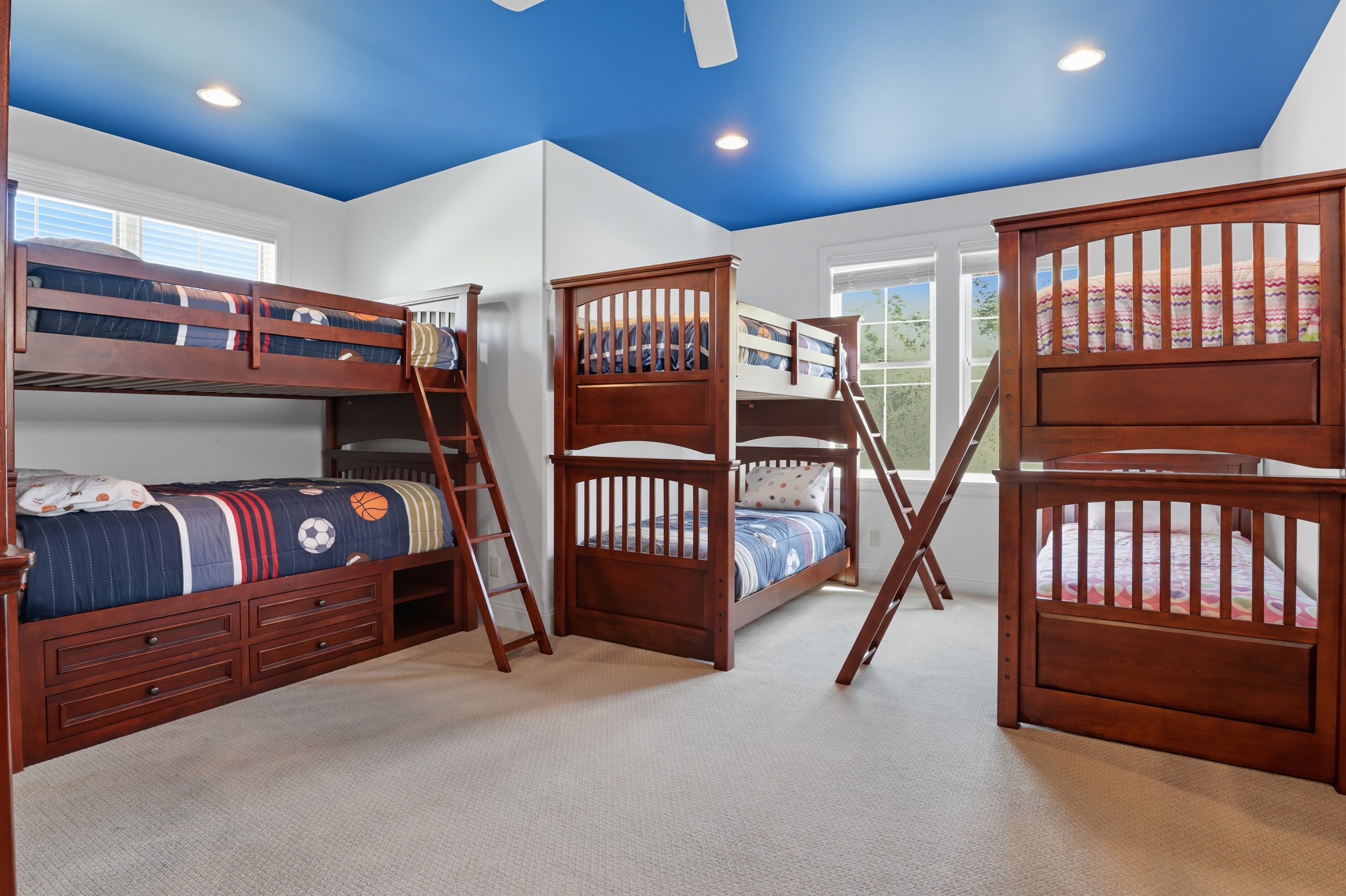Spacious upstairs bunk room with 3 bunks featuring full mattresses on top and bottom and 2 bunks with twin mattresses on top and bottom. Bedroom #5