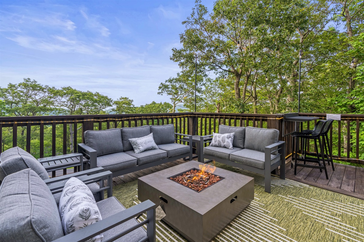 Gather around a modern fire pit on cushioned outdoor seating with distant views and ambient lighting— Evenings feel extra cozy in this elevated mountain escape