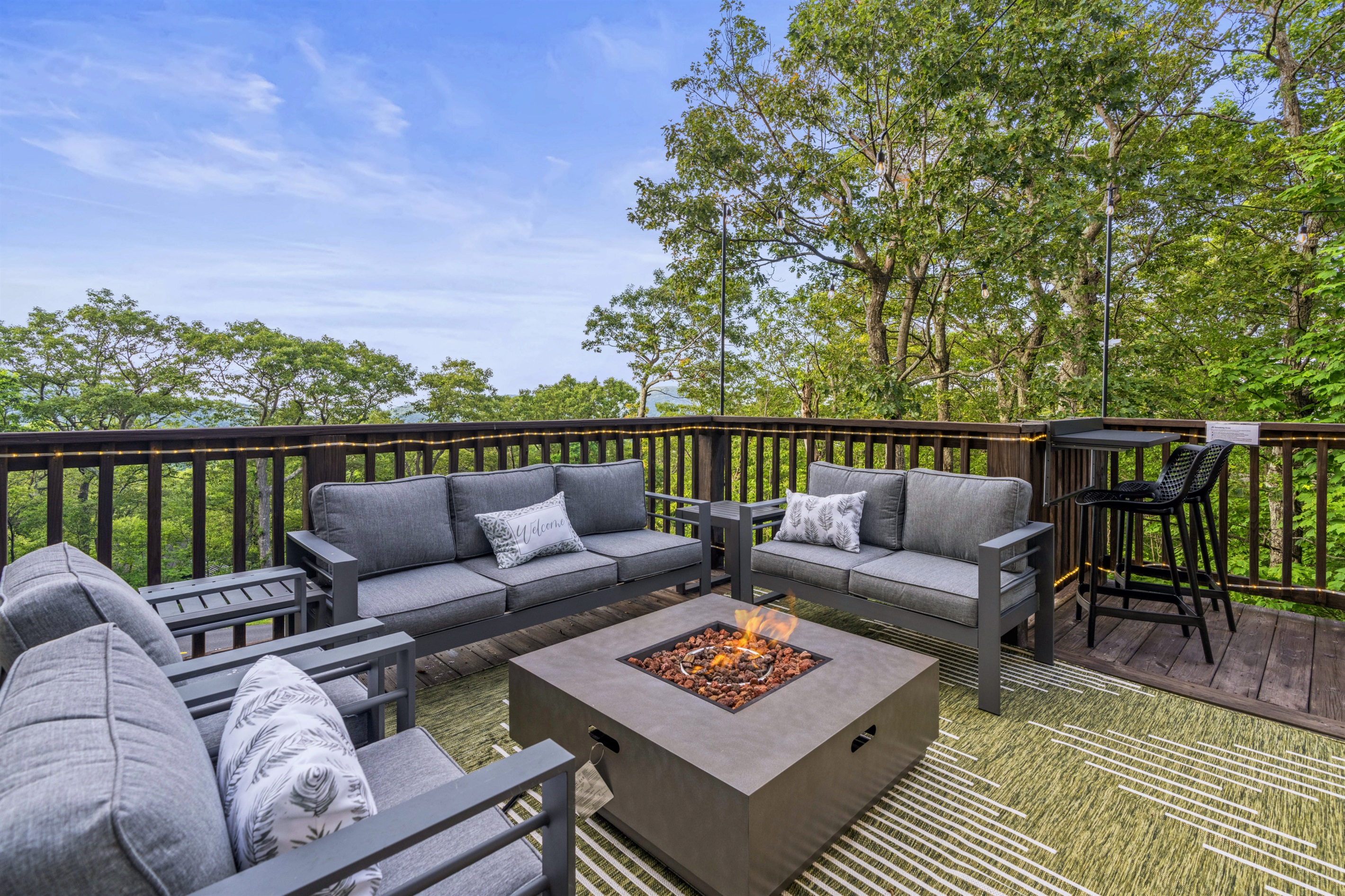 Gather around a modern fire pit on cushioned outdoor seating with distant views and ambient lighting— Evenings feel extra cozy in this elevated mountain escape