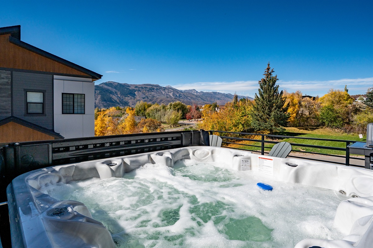 Private hot tub with panoramic mountain views for year-round relaxation.