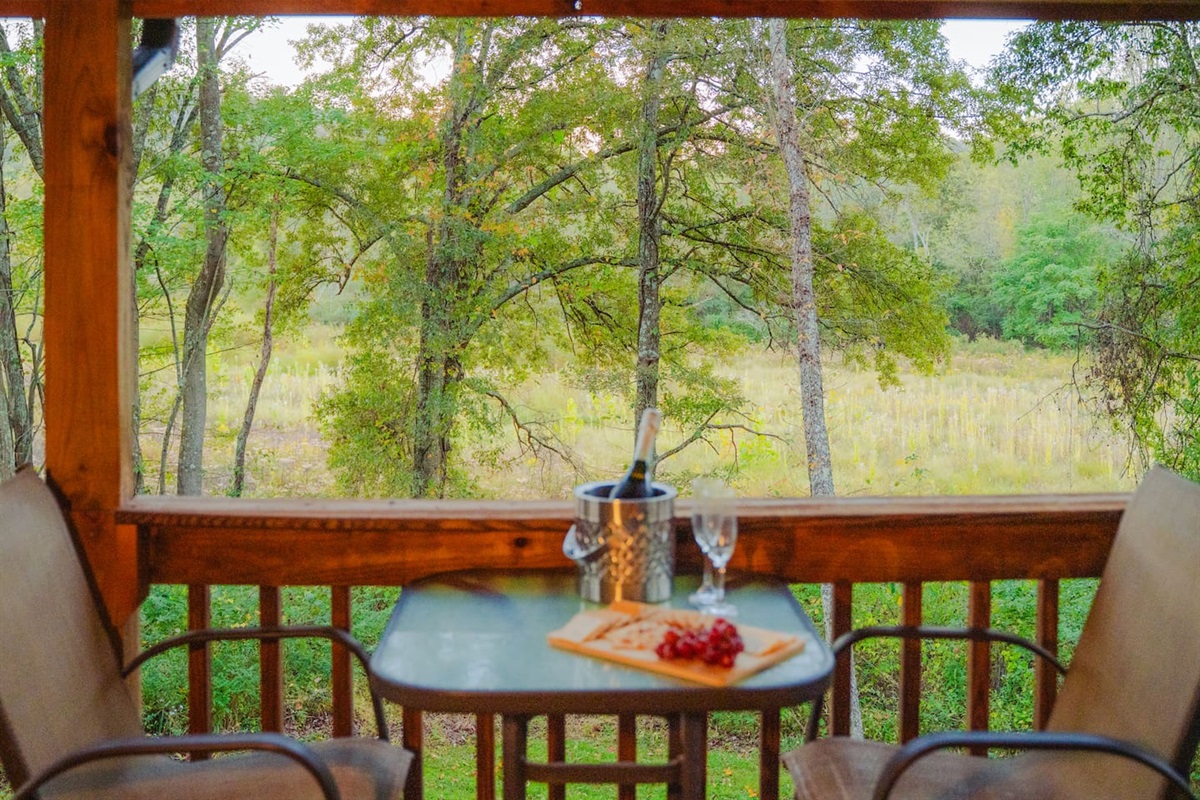 Enjoy peaceful views from the porch, with a table that’s perfect for breakfast or evening drinks