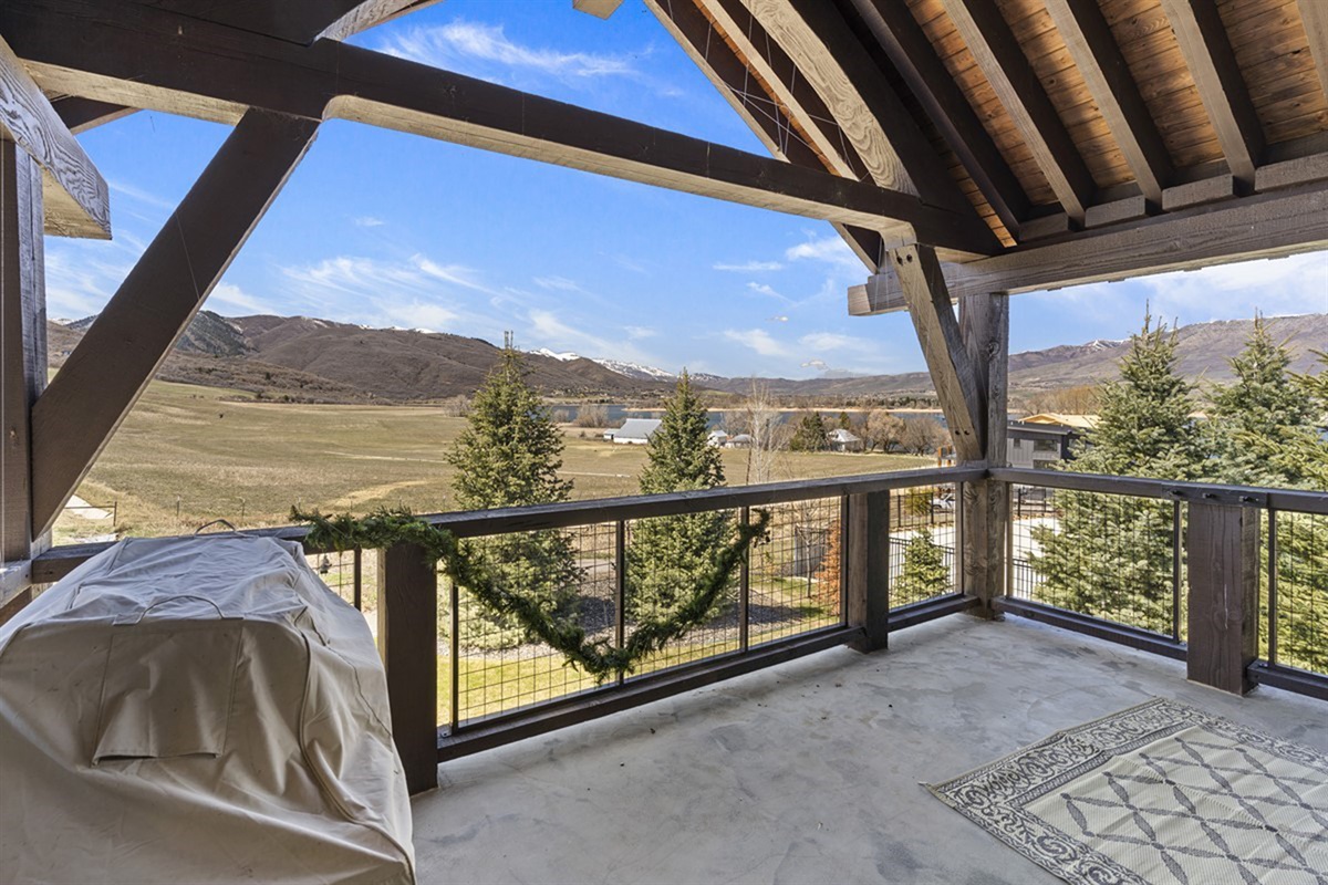 A covered patio sanctuary with a built-in grill and open-air dining, where unobstructed mountain views elevate every outdoor experience.