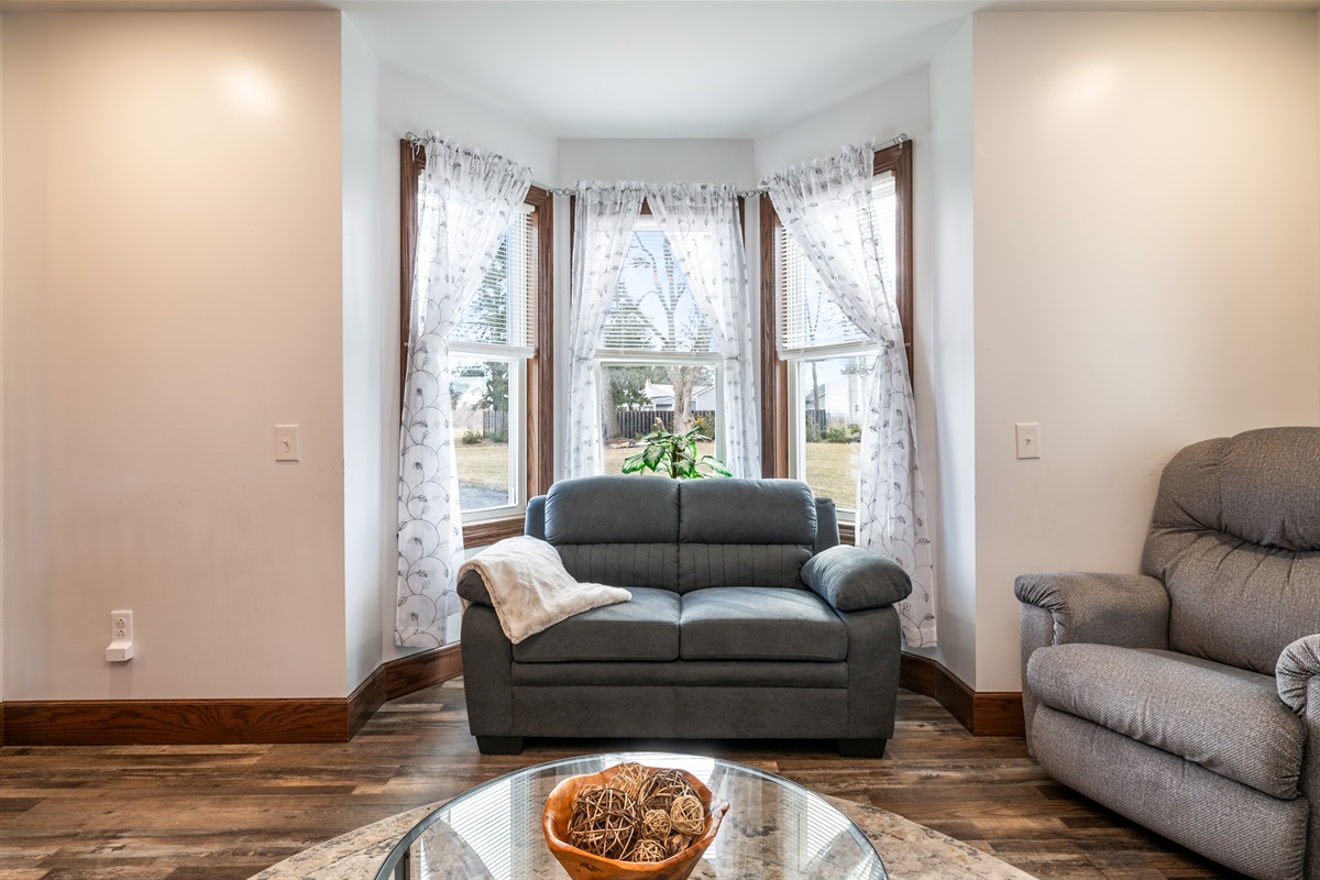 Sun-filled sitting room with beautiful bay windows — a peaceful spot for morning coffee or evening wine