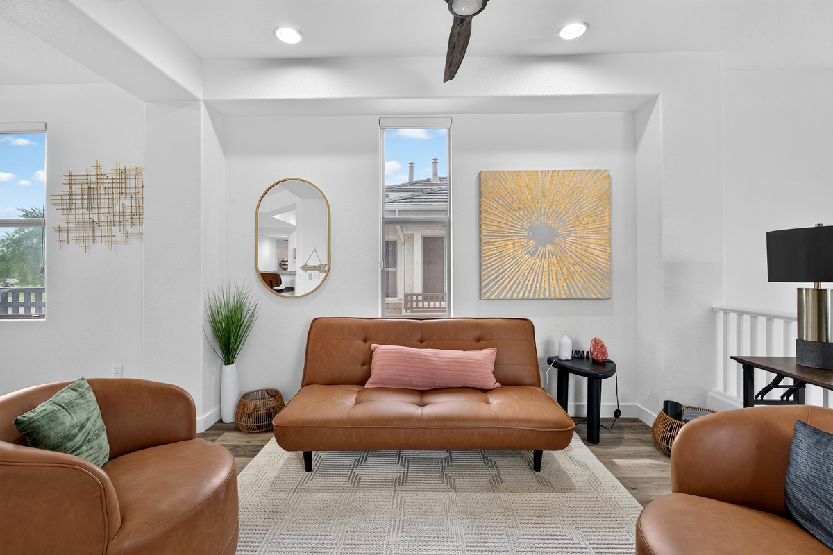 Open sitting area with accent chairs, sofa seating, natural light, and easy flow to the dining and living spaces.