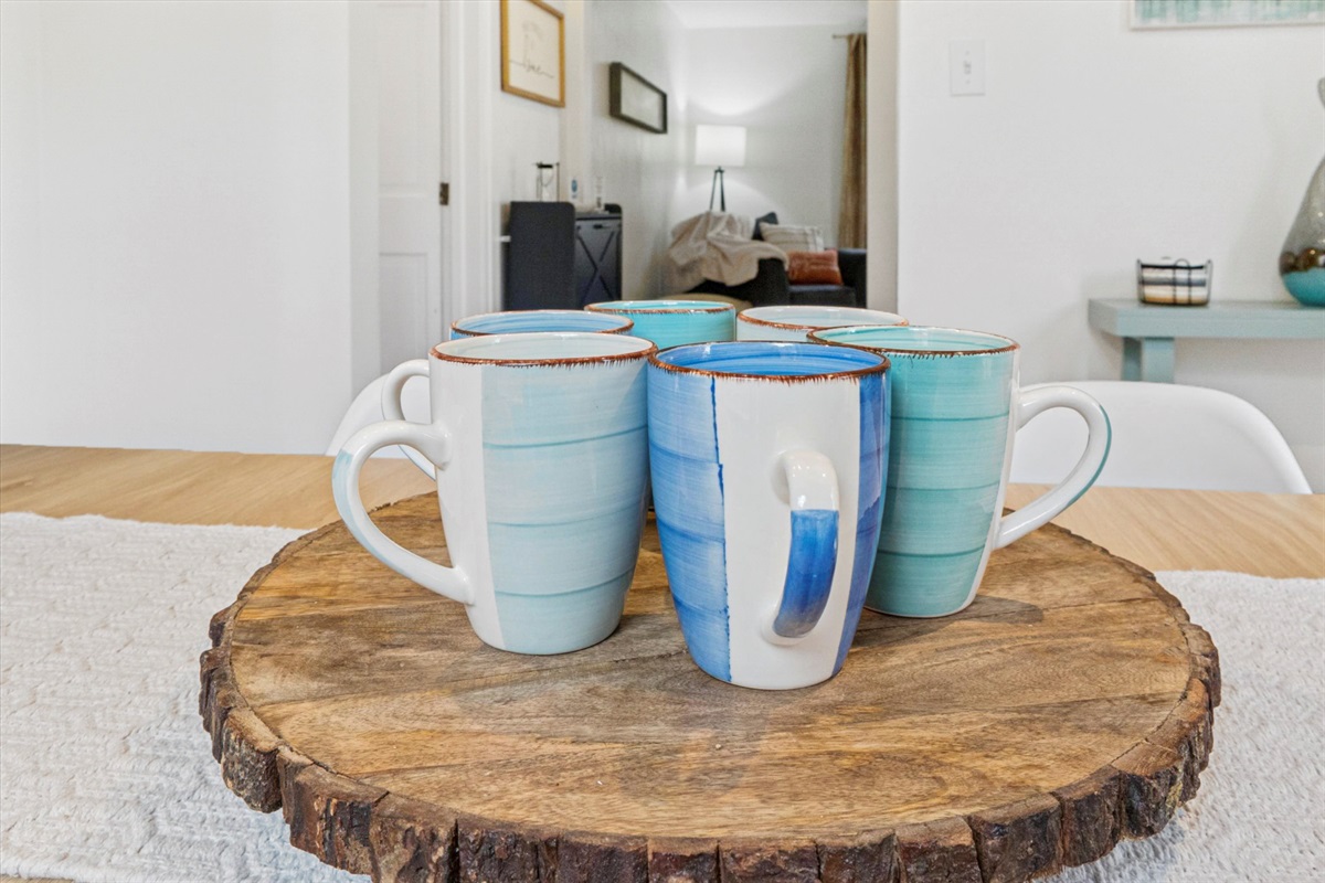 Classy cups circle the lazy Susan in our South Bend dining room, flanked by coasters and a peek at your favorite reading nook—perfect for sipping, gathering, and unwinding near Notre Dame.