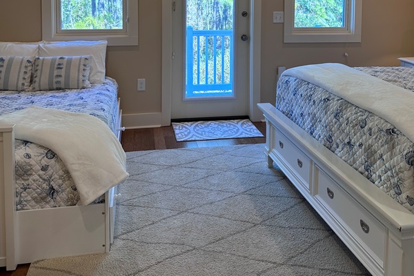 View of the Queen and Full size beds from the en suite bathroom, looking towards the private balcony.