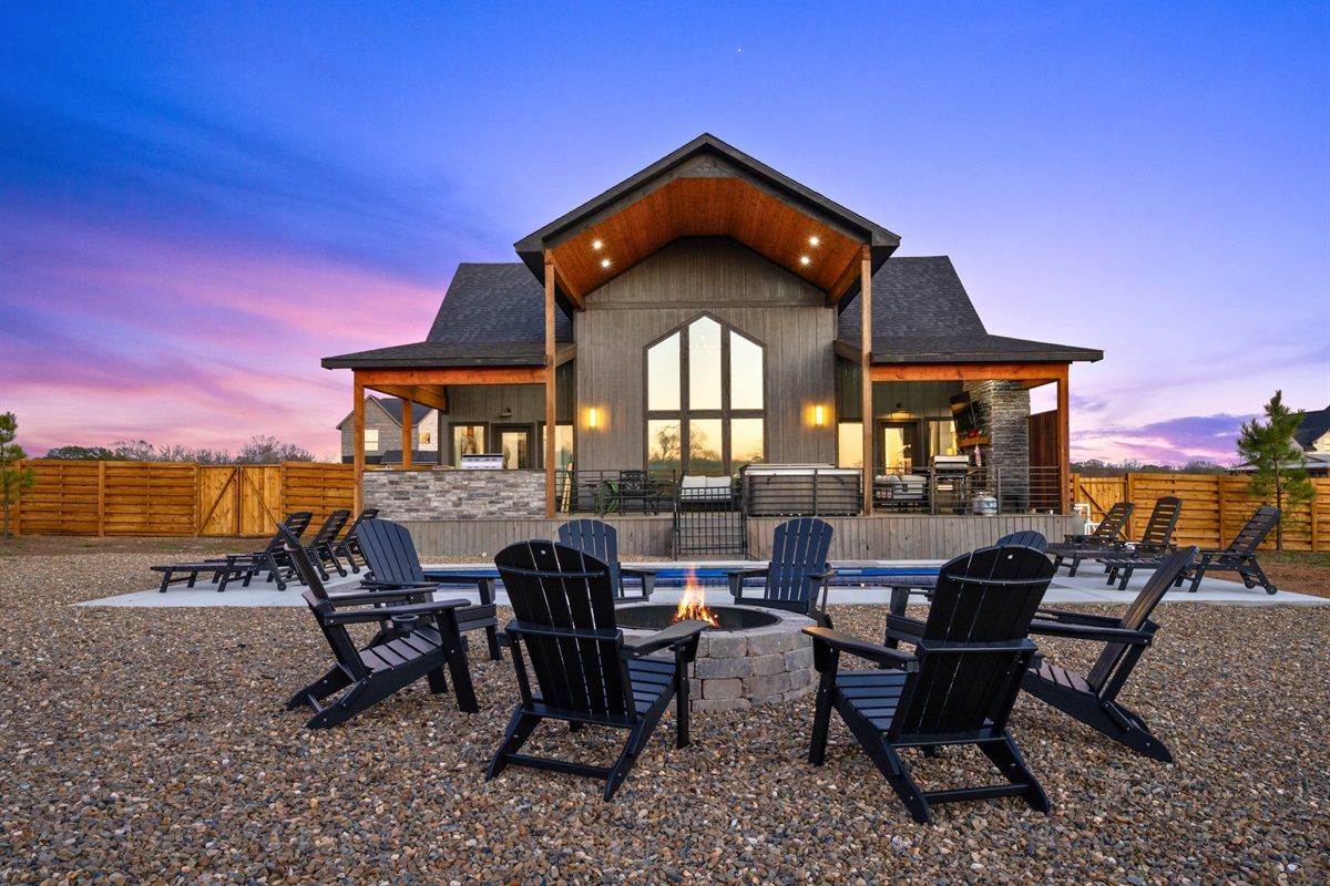 Here’s a closer look at the backyard setup, complete with comfortable seating that wraps around the fire pit and outdoor living spaces.