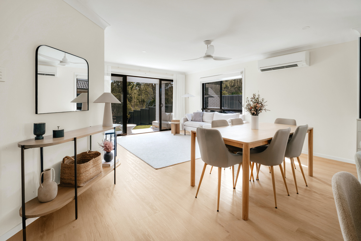 From the kitchen area, the view carries through the lounge to the patio and leafy backyard beyond.