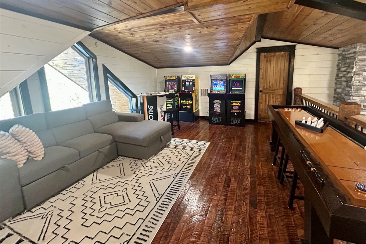 Game room with shuffleboard and arcade matchines