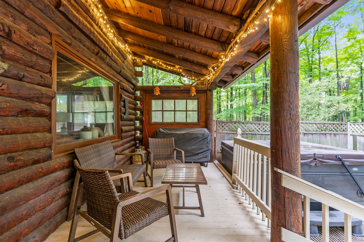 Relax on the covered porch with rocking chairs, rustic log seating, and warm ambiance perfect for morning coffee or evening sunsets.