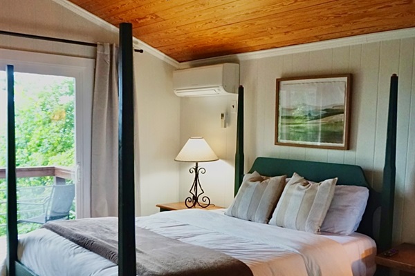 Bedroom Bliss: Relax in style with a plush bed, scenic views, and warm wooden accents!