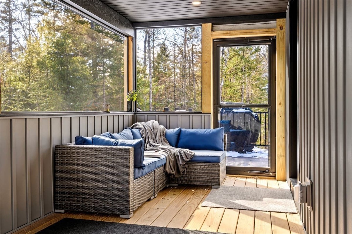 Sunroom serenity.  This cozy corner is the perfect spot to curl up with a book and enjoy the view.