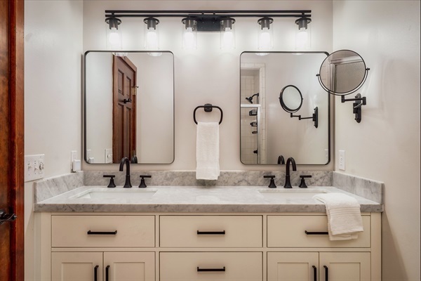 Modern bathroom with double vanity and sleek black fixtures.
