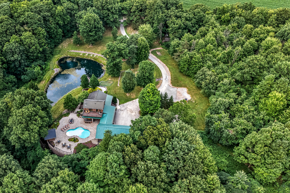 House and pond surrounded by trees