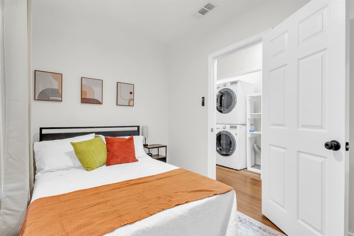 Bedroom with full bed, plushing bedding, room darkening shades, and modern decor.