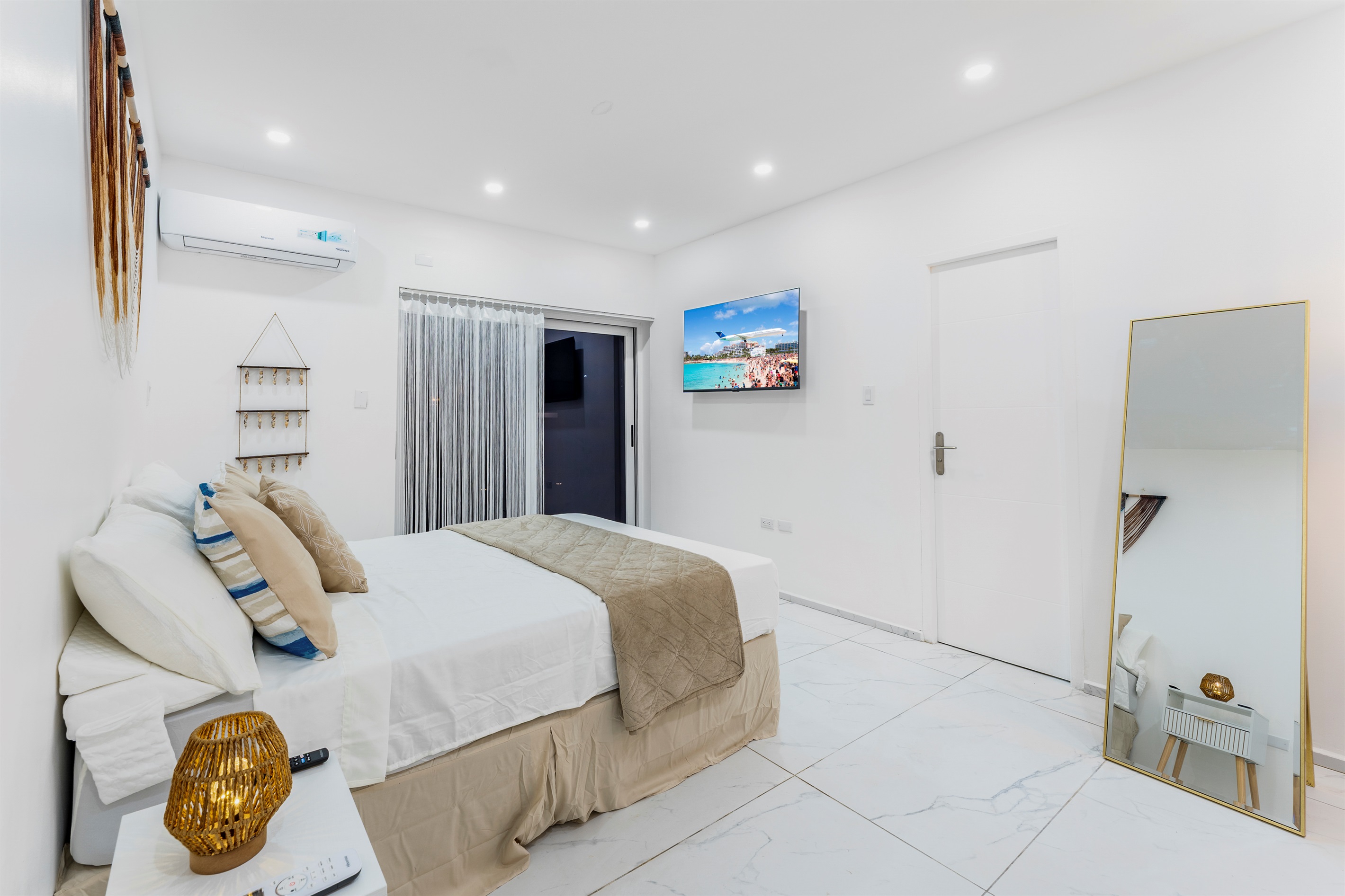 Ground floor bedroom angle showing TV, sliding door and full-length mirror