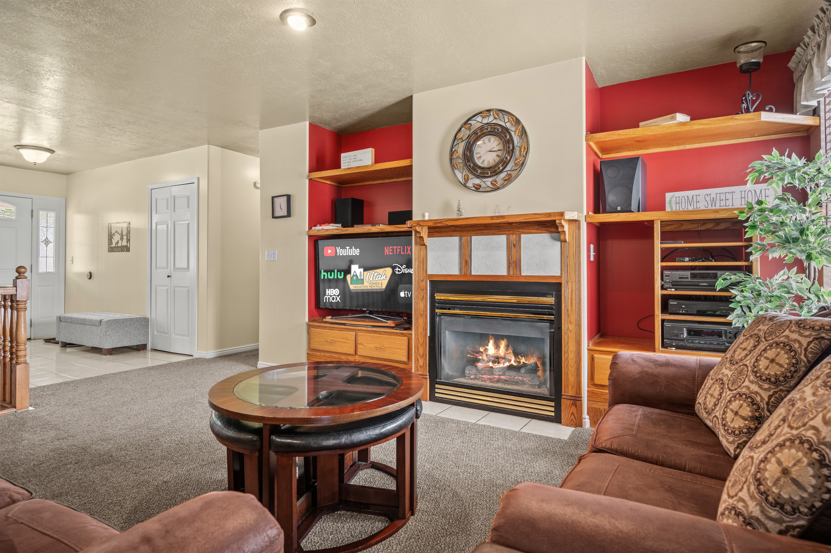 Bright, comfortable main-level living space featuring plush seating, fireplace, and entertainment center.