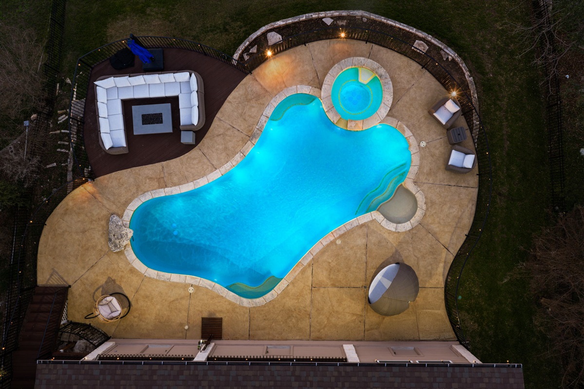 Top-down evening view of the private pool and spa — a stunning backyard retreat under the lights.