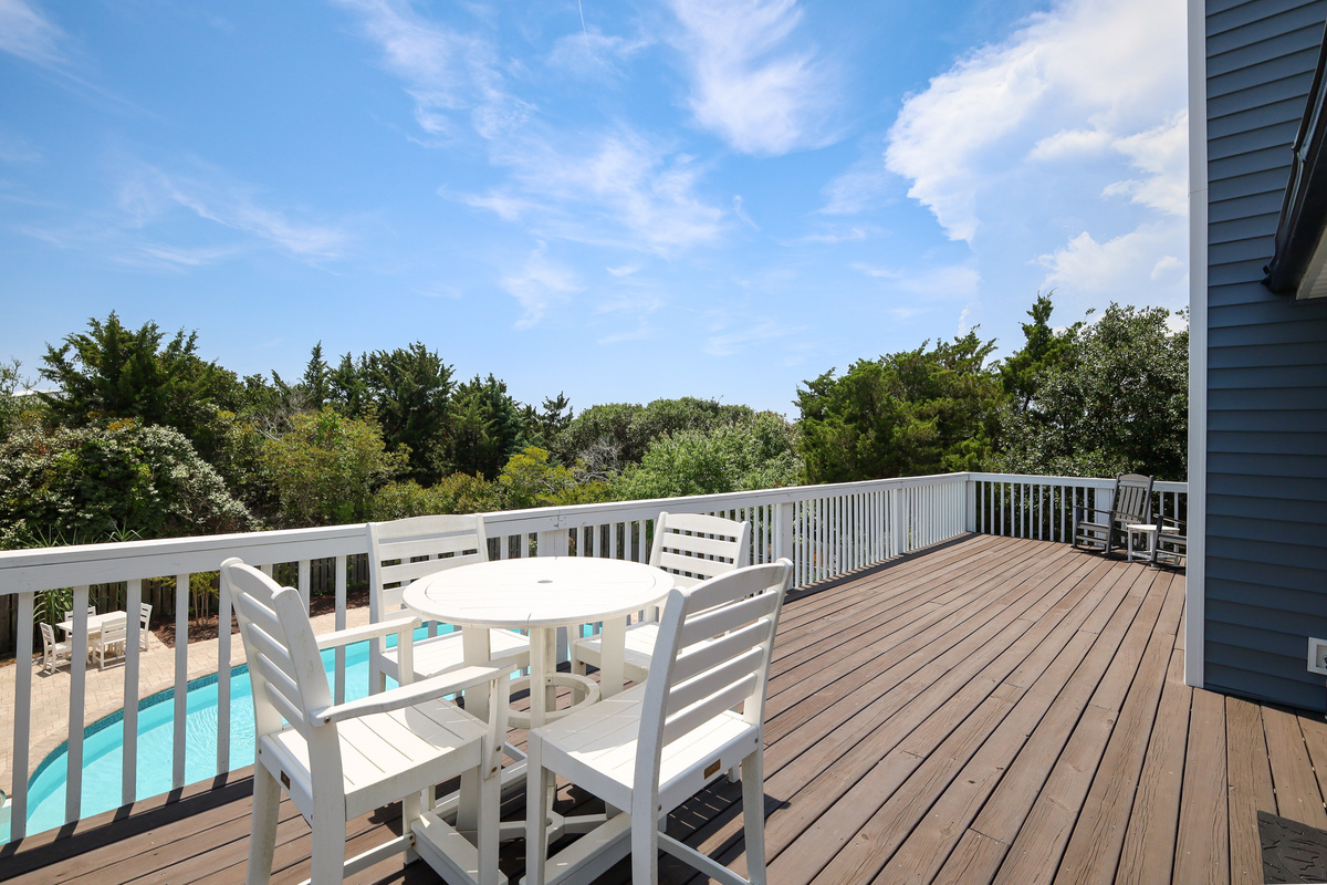 The expansive upper deck overlooks the private pool and offers plenty of space for outdoor dining, relaxing, and gathering with family and friends