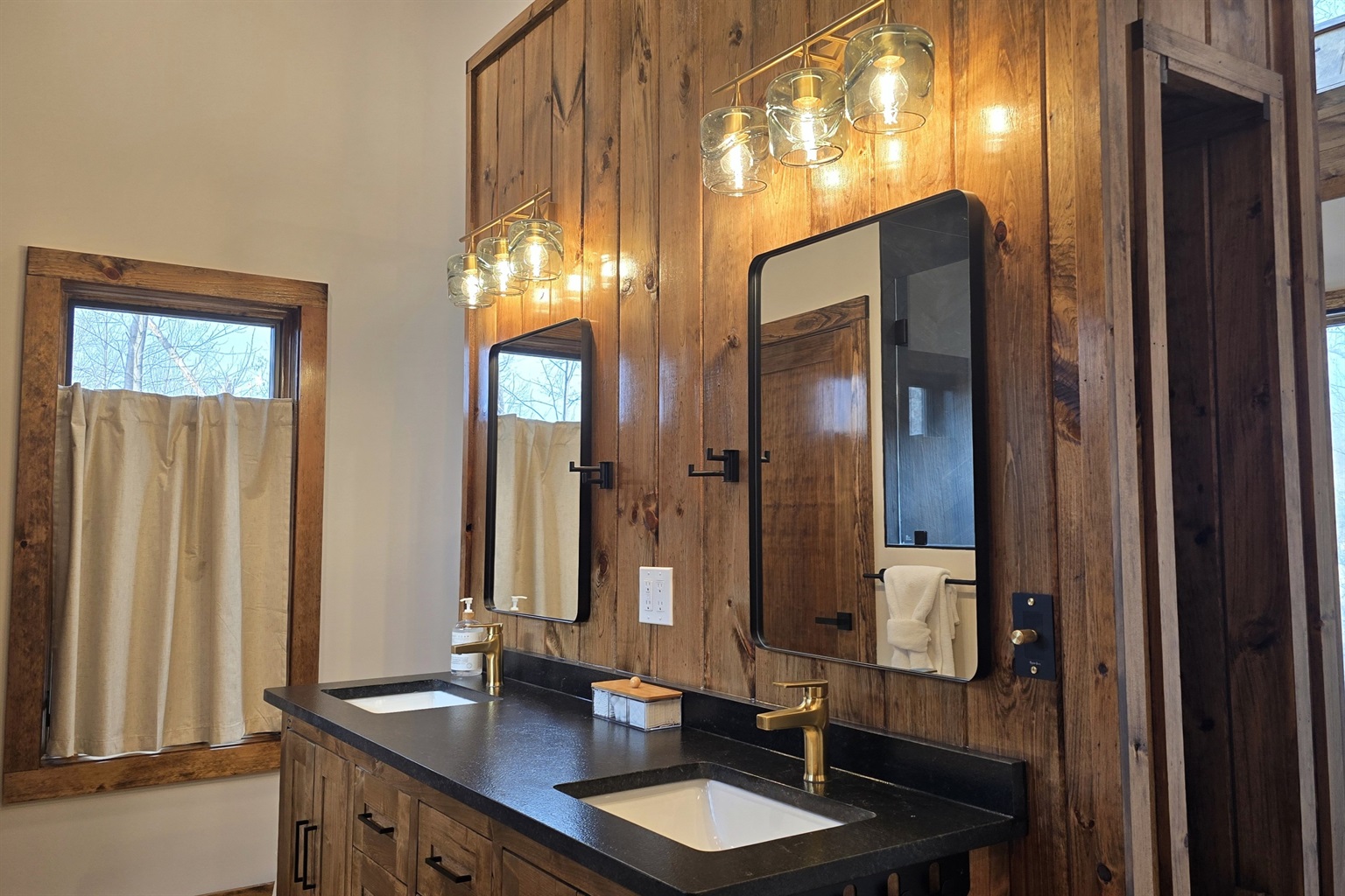 Custom double vanity wall featuring recycled glass light fixtures and floating vanity