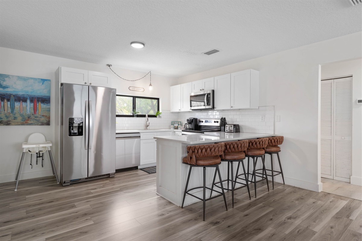 In this bright coastal kitchen, mornings start with pancakes at the island, little feet swinging from the stools, and coffee brewing before a beach day begins. By night, everyone gathers back here, sharing takeout, stories, and one more laugh together.