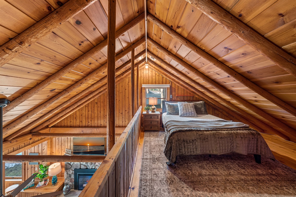 The loft bedroom overlooking the living room has a queen bed, black-out shades and a small dresser for storage.  
