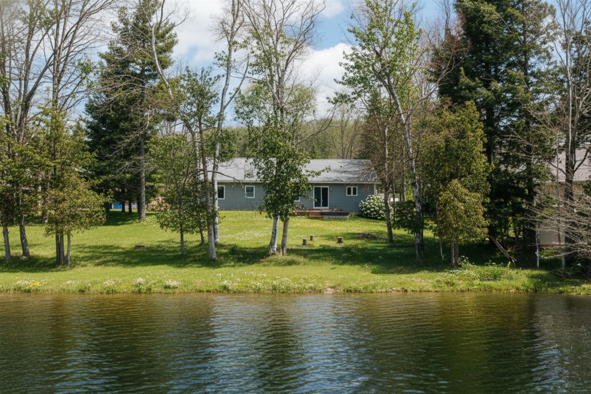 Enjoy peaceful lakefront living at Shorebird, where calm waters, grassy shoreline, and towering trees create an ideal setting for swimming, paddling, and relaxed summer days.