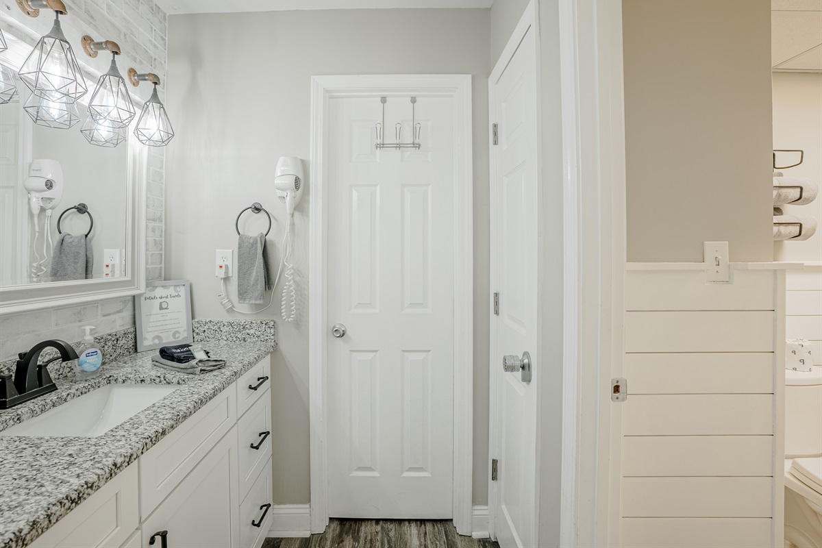 Vanity area off master bedroom with hair dryer and large walk-in closet