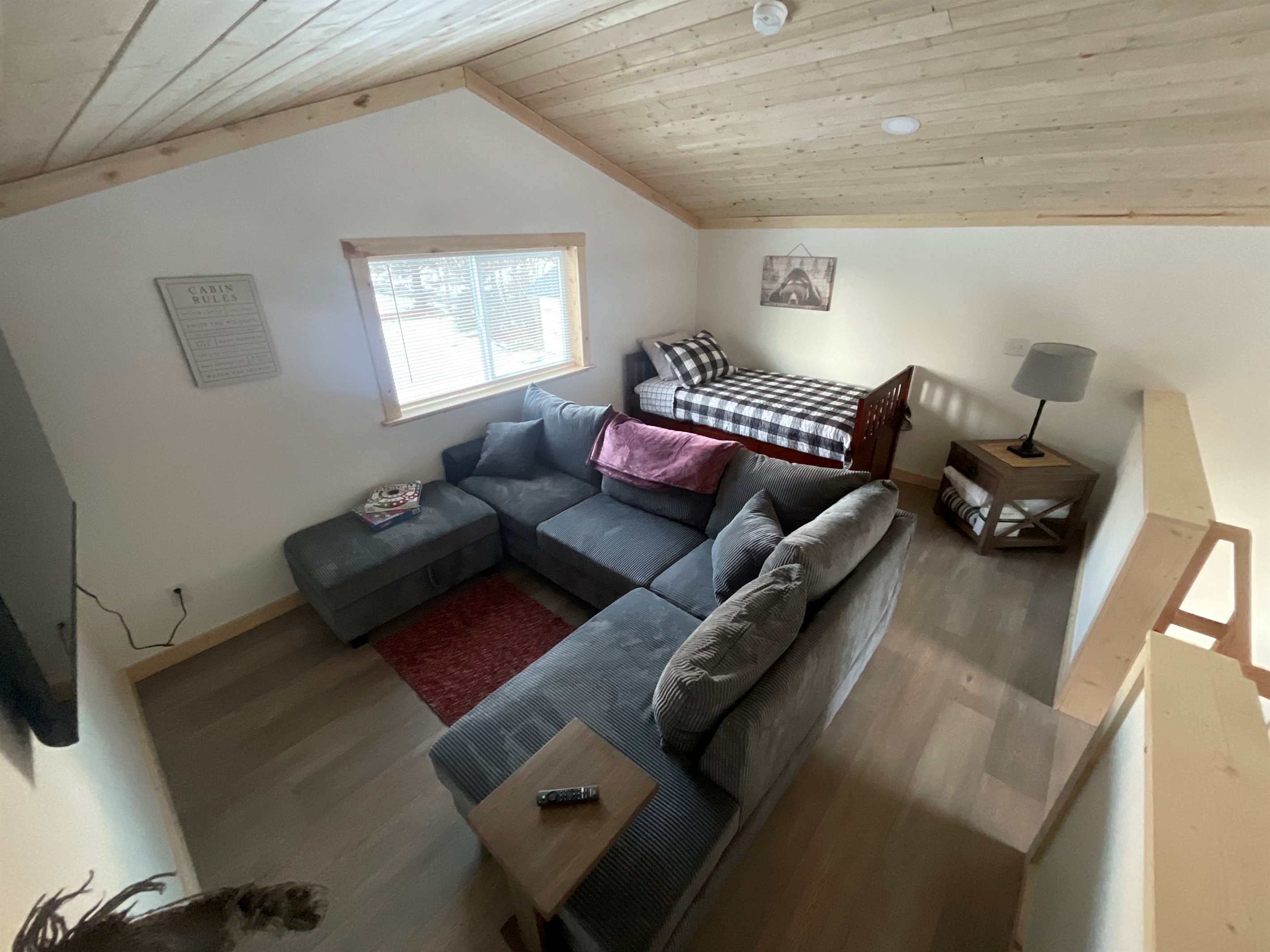 Loft area includes sectional sofa and additional bed (twin bed with trundle bed) [Photo is representative but may not be from this cabin].