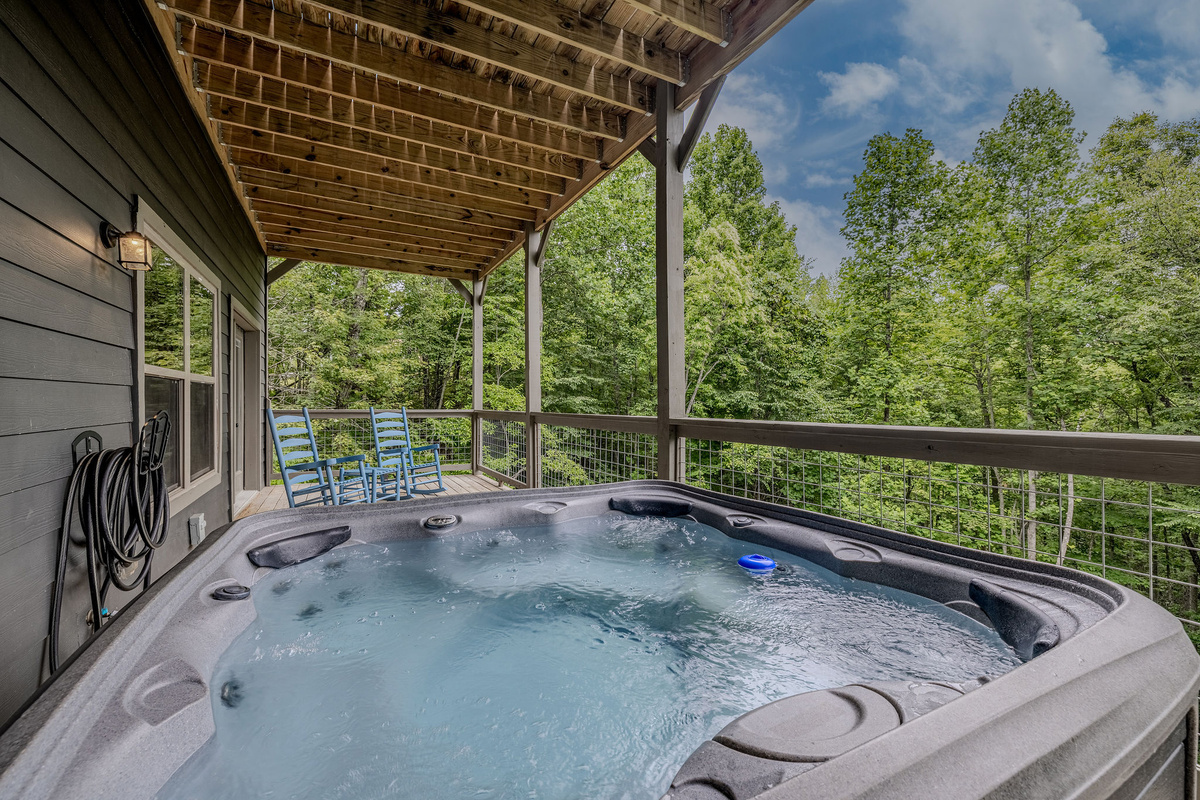 Blue Smoke Soak offers a private hot tub experience surrounded by the wooded mountain setting.