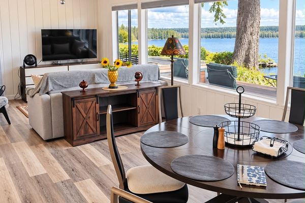 An open, connected living and dining space designed for relaxing and gathering, featuring a king-size pull-out sofa for added sleeping space.