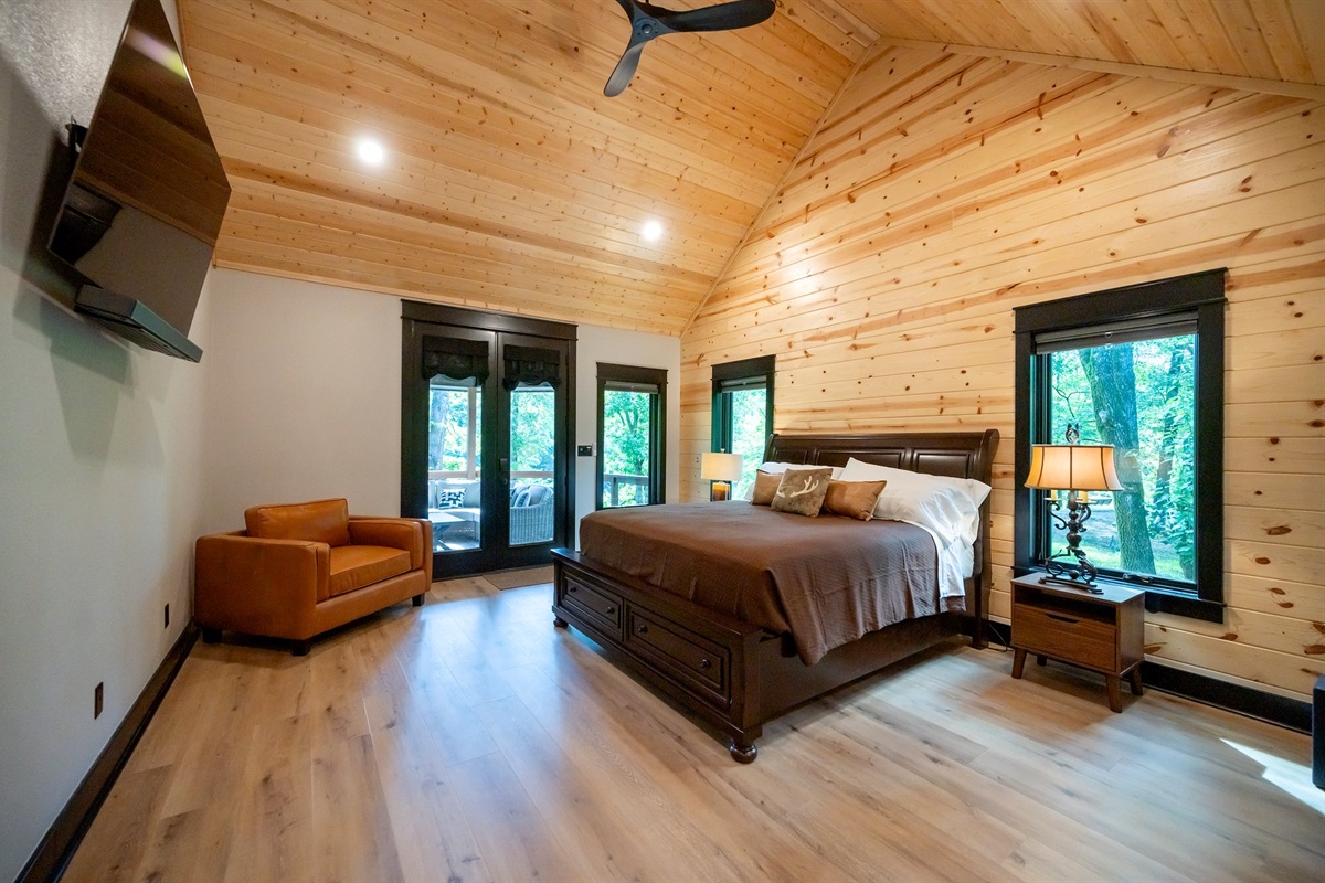 Master bedroom with doors to outside seating and fireplace.