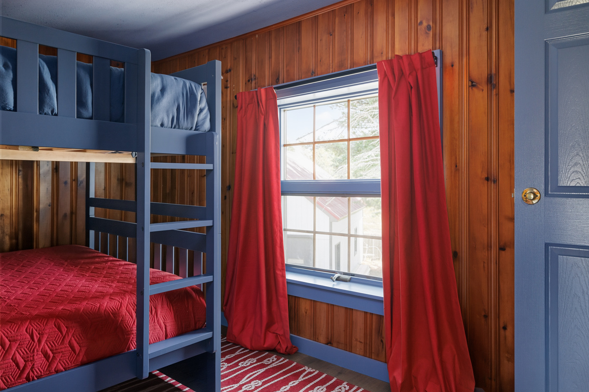 Bedroom four is where the late risers end up — quieter corner of the house, blackout shades available, sleeping in actively supported.