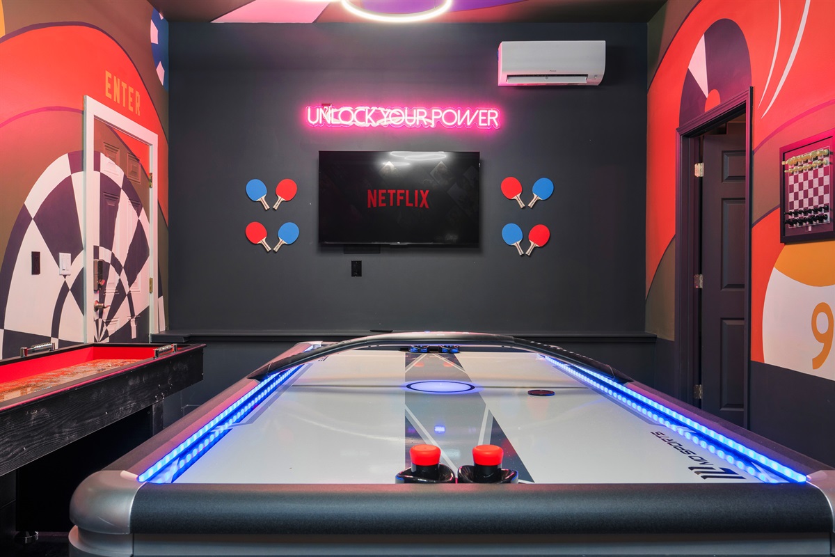 Game room with neon accents and mounted TV - great for late-night hangouts after exploring Asheville’s brewery scene