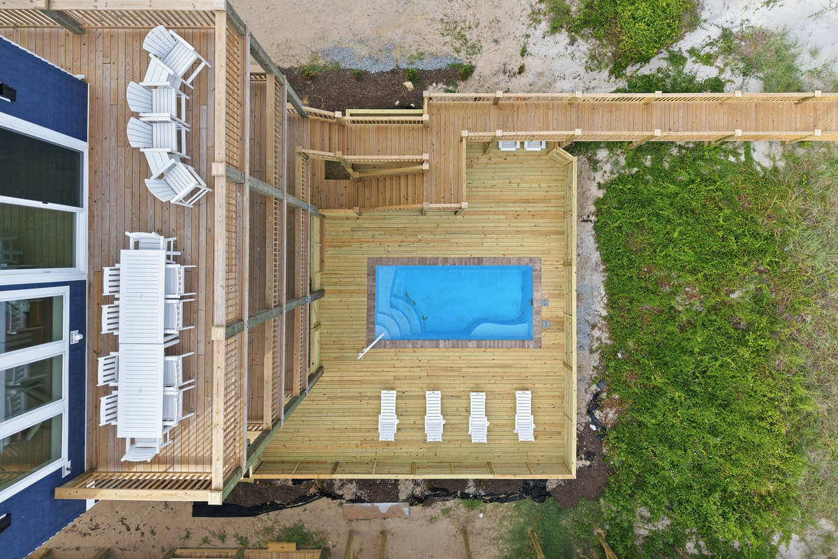 Aerial view of private pool deck with lounge chairs and surrounding oceanfront deck layout