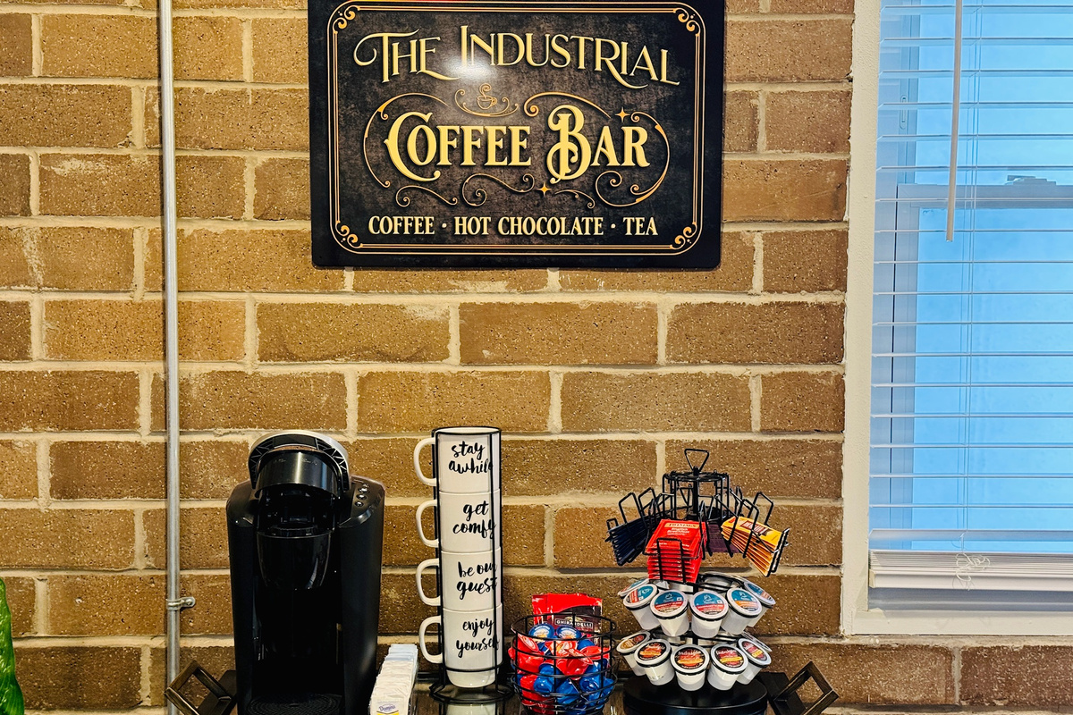Coffee bar includes a Keurig, coffee pods, tea, cocoa, and sweeteners.