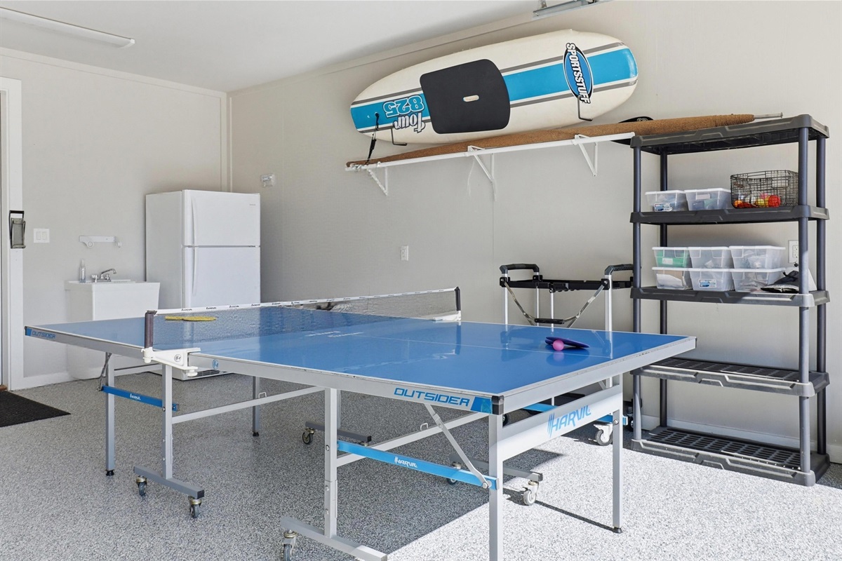 Garage opens to covered patio space and pool to get a ping pong game going