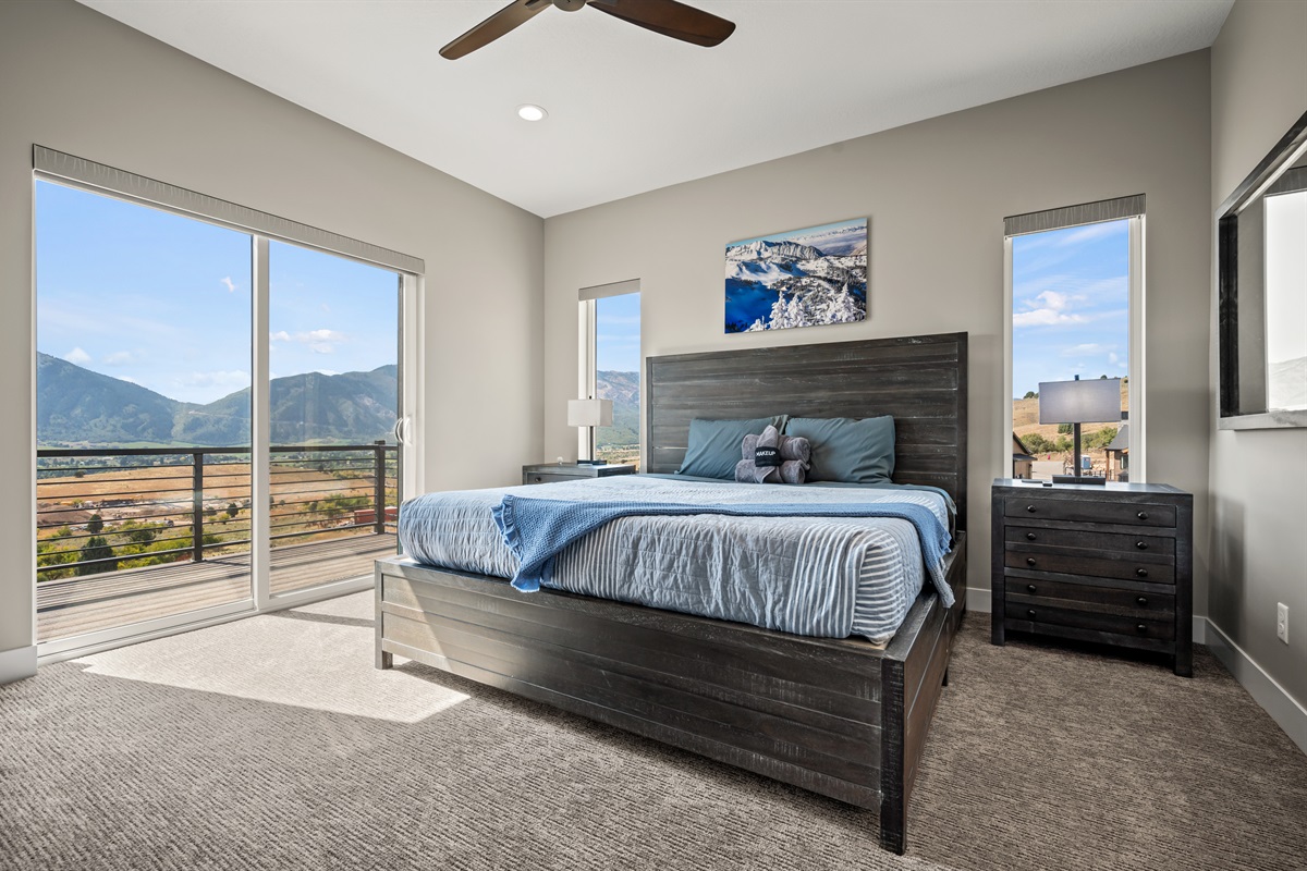 Primary king suite with balcony access and panoramic mountain scenery
