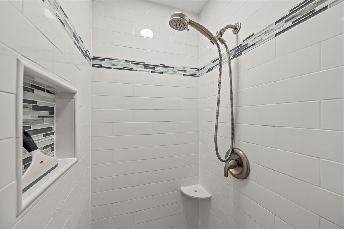 Clean tile walk-in shower with built-in niche and modern fixtures