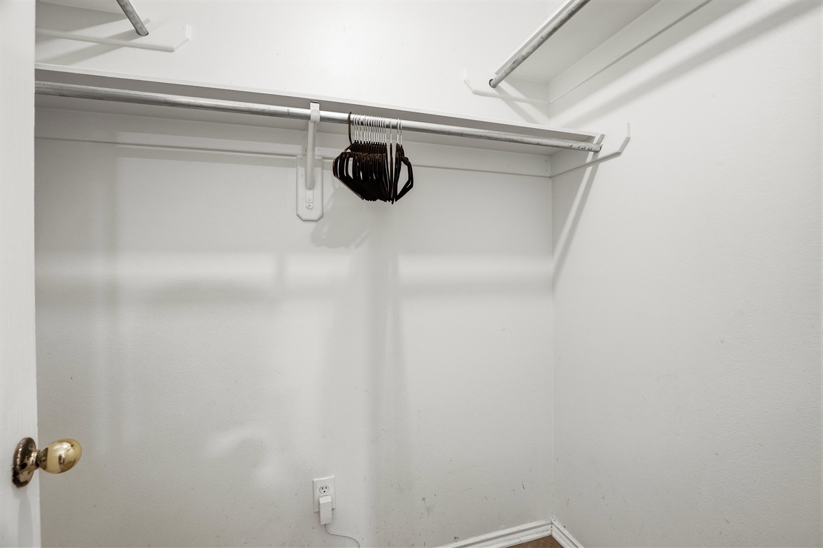 Spacious walk-in closet in the primary bedroom with full hanging rod, upper shelving, and hangers provided. Plenty of room to unpack and settle in for longer stays.