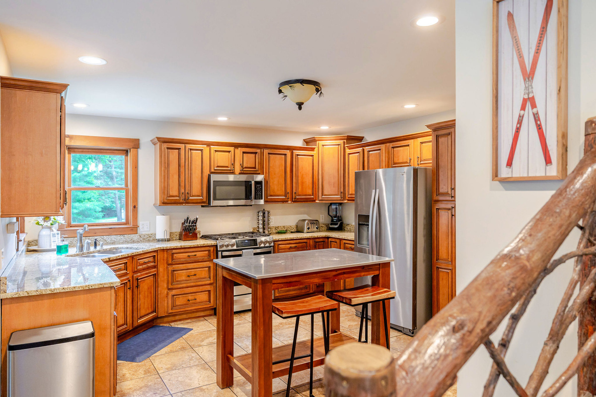 Fully equipped gourmet kitchen with granite countertops, stainless steel appliances, and ample workspace.