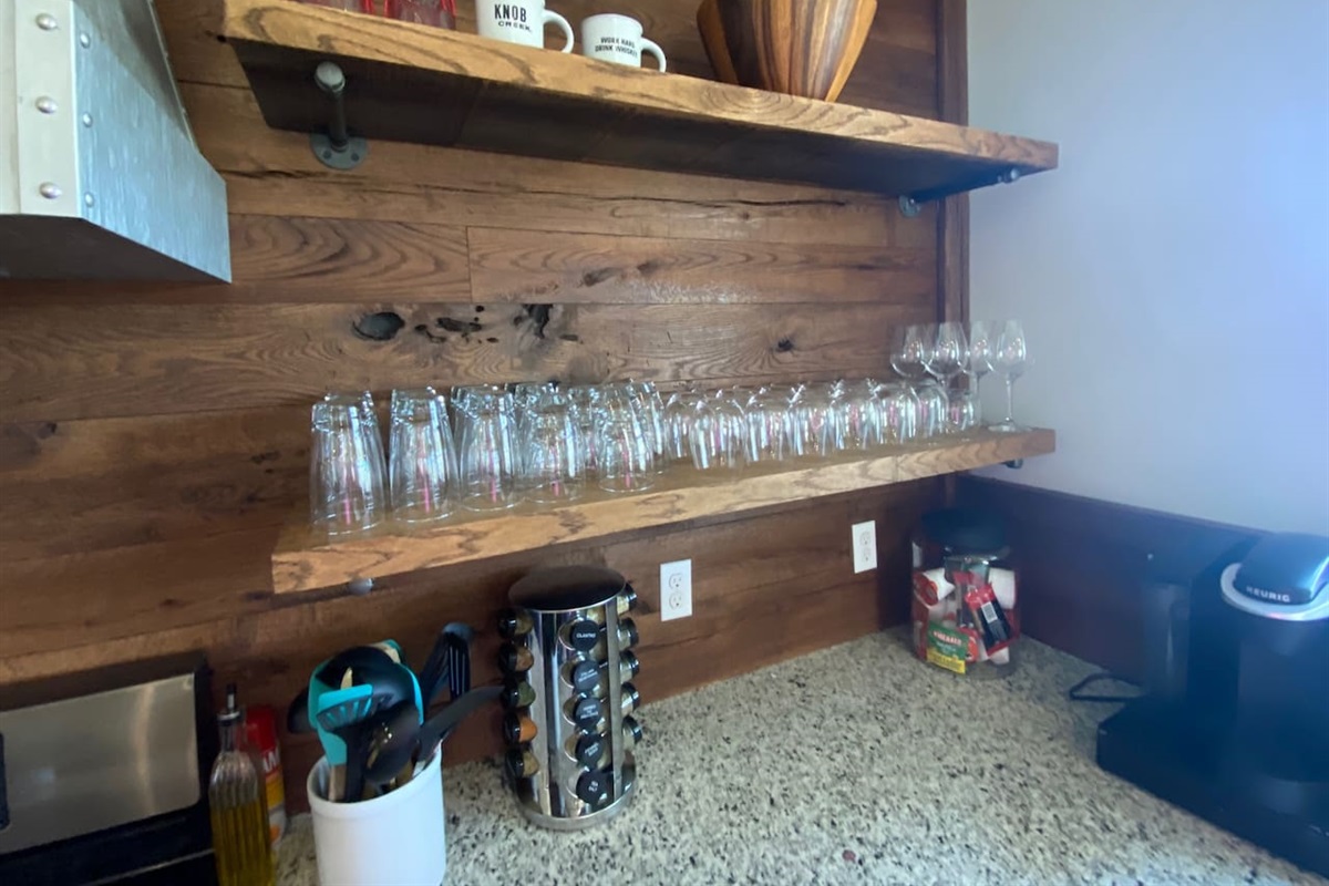 Drinking glasses and wine glasses for entertaining along with spices and some utensils for cooking.