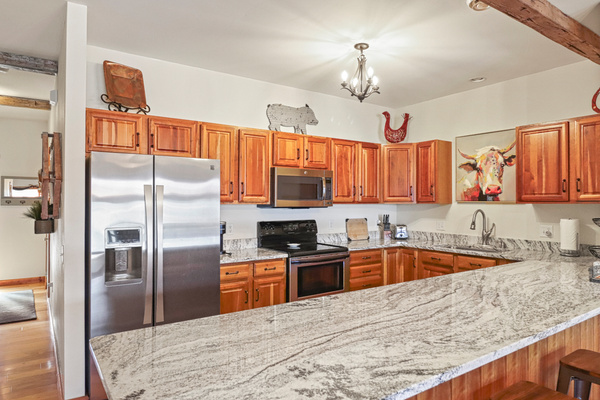 Large quartz countertops, breakfast bar with stools.